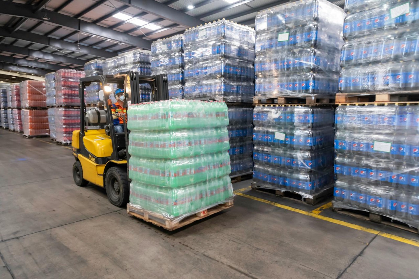 Forklift operating inside a busy warehouse and logistics facility